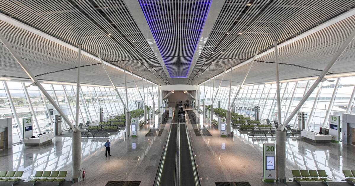 An almost empty airside concourse at Brasília International Airport, a moving walkway running down the centre between gate markers