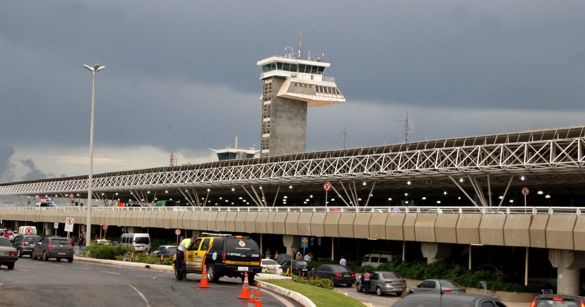 Brasília airport's control tower above the terminal's elevated roadway and curbside in February 2015, under a stormy sky