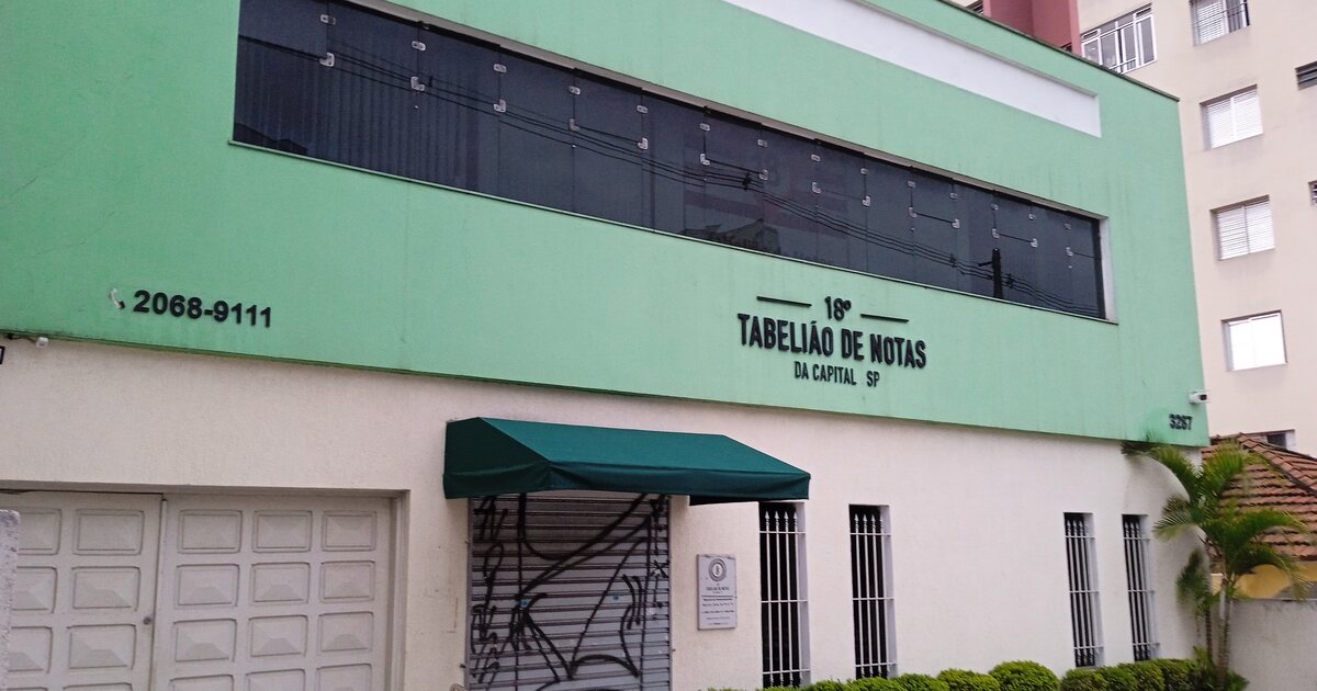 The street front of a notary office in Sao Paulo, its raised lettering reading 18o Tabeliao de Notas da Capital SP above a green awning