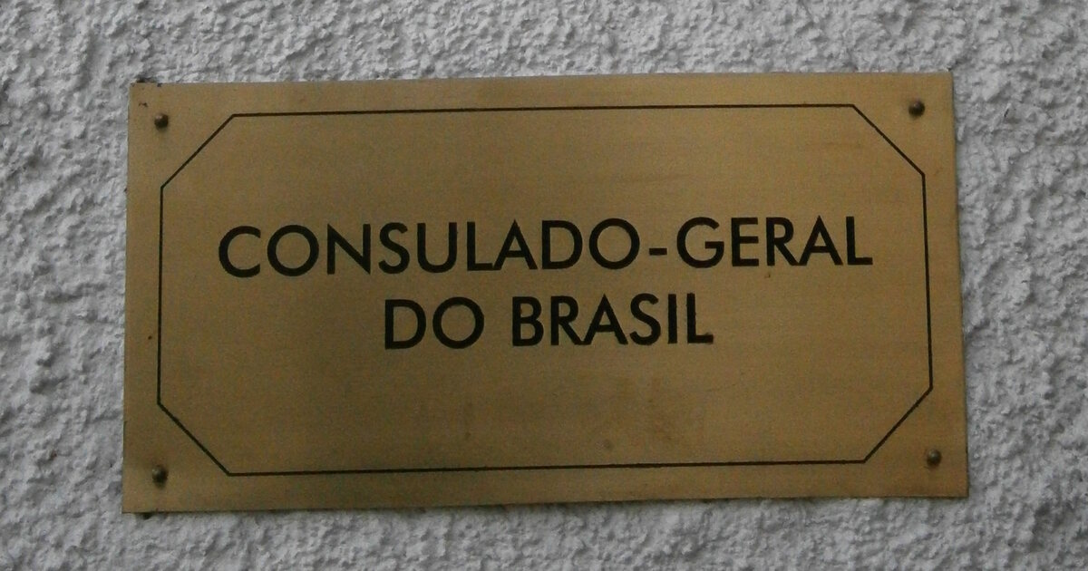 A weathered brass plaque reading CONSULADO-GERAL DO BRASIL fixed to a white rendered wall