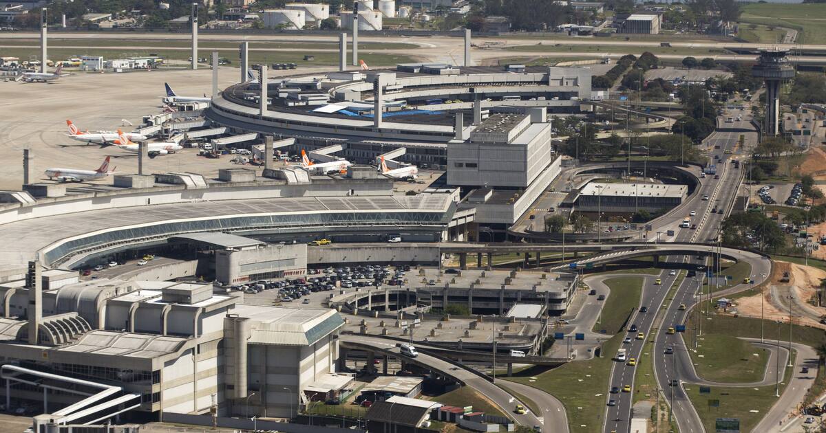 Aerial view of Rio de Janeiro's Galeão airport in 2013, with Terminal 2 in front, the round Terminal 1 behind, the control tower and access roads with yellow taxis