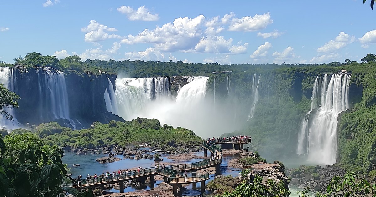The Iguaçu Falls seen from the Brazilian side, with the visitors' walkway on the rocks below and spray rising off the far drops