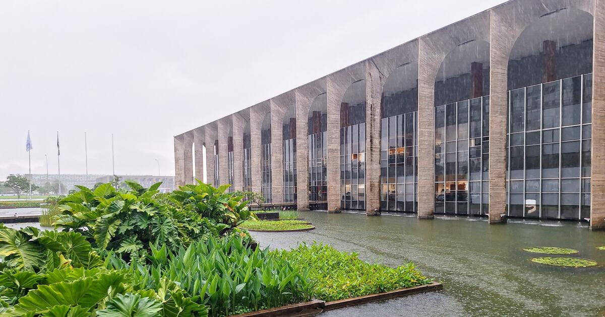 The concrete arcade of the Itamaraty Palace in Brasília reflected in its water garden during heavy rain