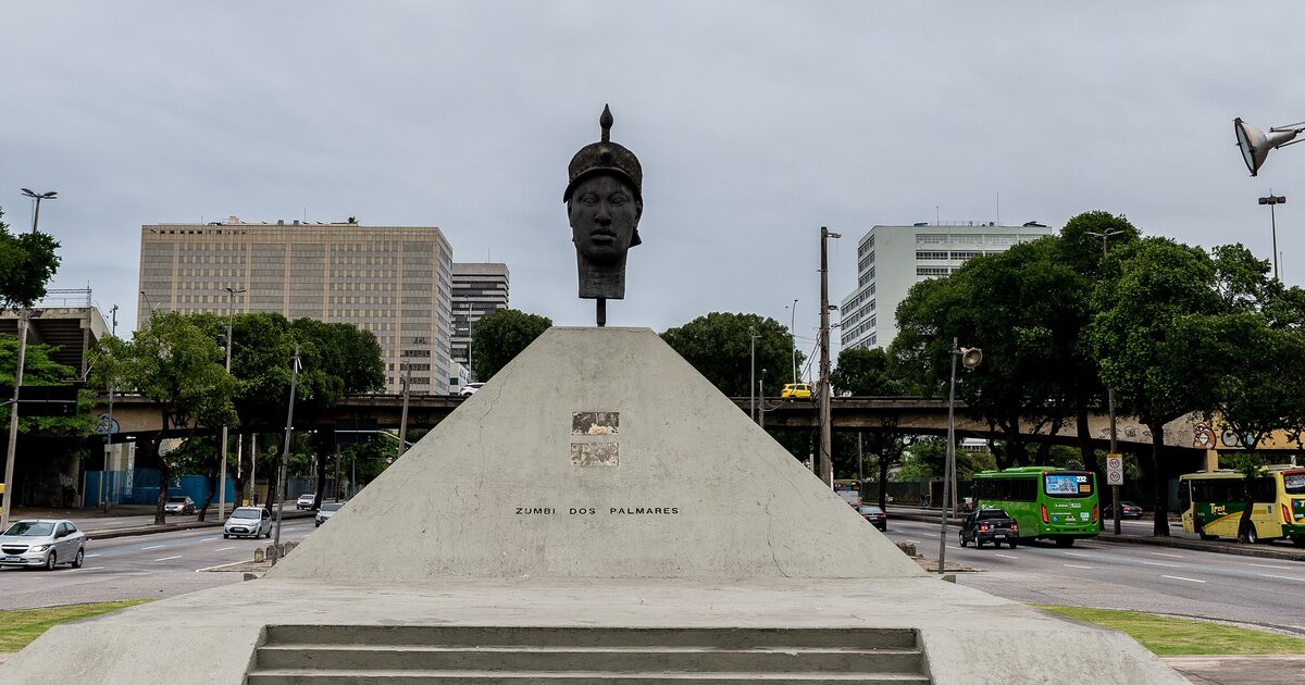 The Zumbi dos Palmares monument in central Rio de Janeiro, a bronze head on a concrete pyramid beside a city avenue