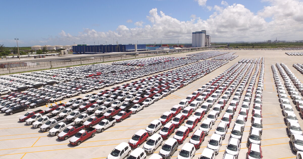 An aerial view of hundreds of new cars parked in rows in the vehicle yard of the port of Suape, Pernambuco